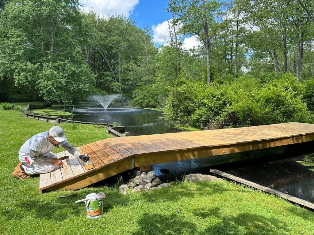 professional painter staining outdoor deck